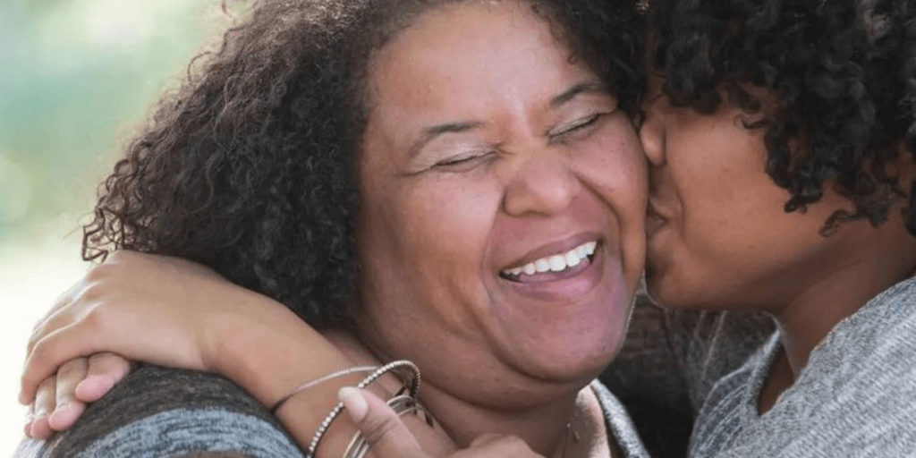 Daughter kissing mom on the cheek