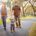 family wearing masks at the park