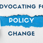 An image of a torn piece of paper with the word Advocating at the top and policy revealed by the torn paper with change at the bottom.