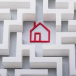 The outline of a home made with red yard in the middle of a maze with white walls and a gray floor.