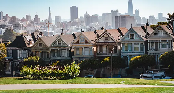 A line of San Francisco houses against the San Francisco Skyline. 