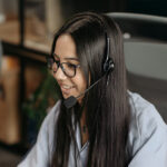 A young female appearing individual participating in a call center as a phone operator.