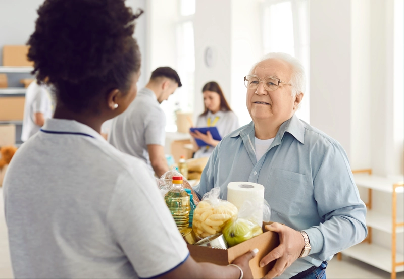 An older individual receiving a box of food.