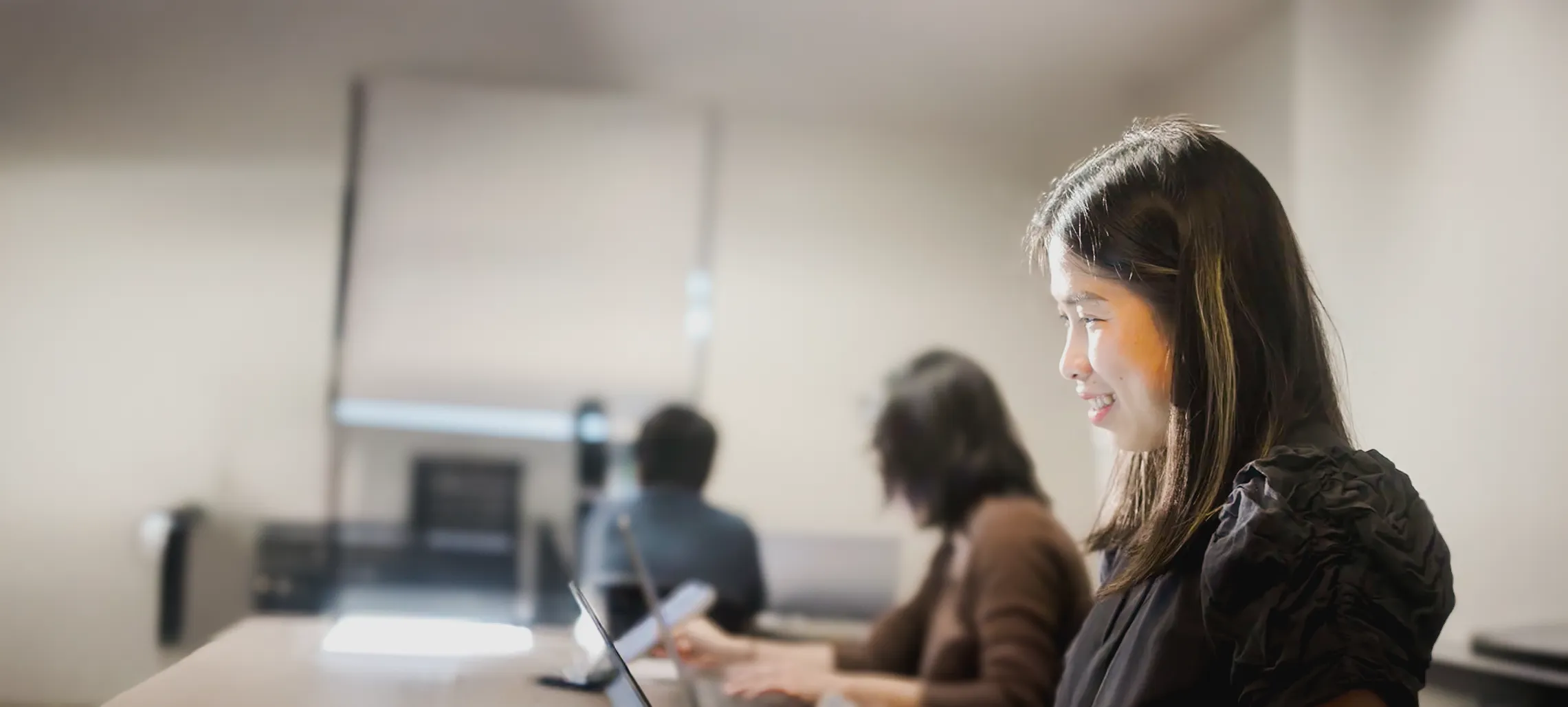 An individual with others in a center of sorts working on a computer.
